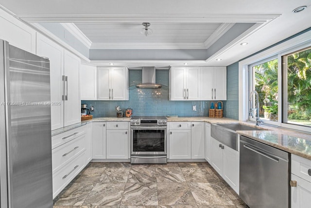 kitchen featuring white cabinetry, wall chimney range hood, and appliances with stainless steel finishes