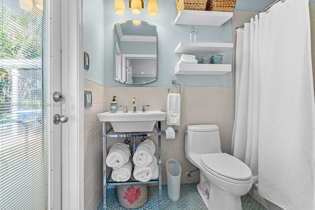 bathroom featuring tile walls, a shower with curtain, ornamental molding, and toilet