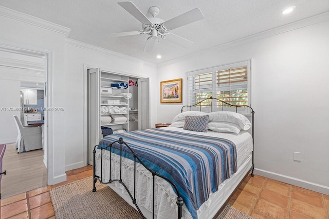 bedroom featuring ceiling fan, ornamental molding, a closet, and a textured ceiling