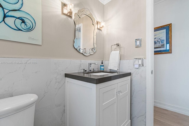 bathroom with vanity, toilet, hardwood / wood-style floors, and tile walls