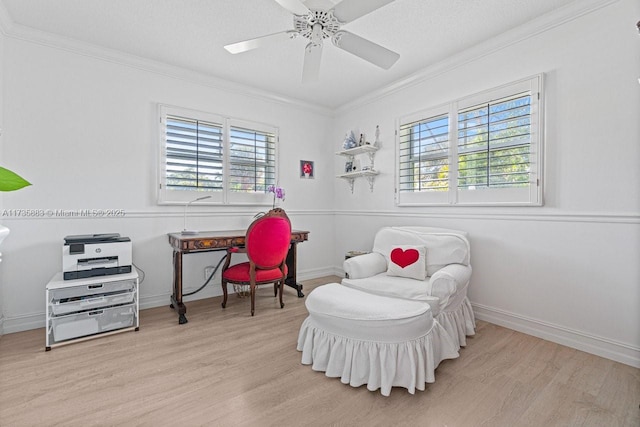 sitting room featuring ceiling fan, ornamental molding, light hardwood / wood-style floors, and a textured ceiling