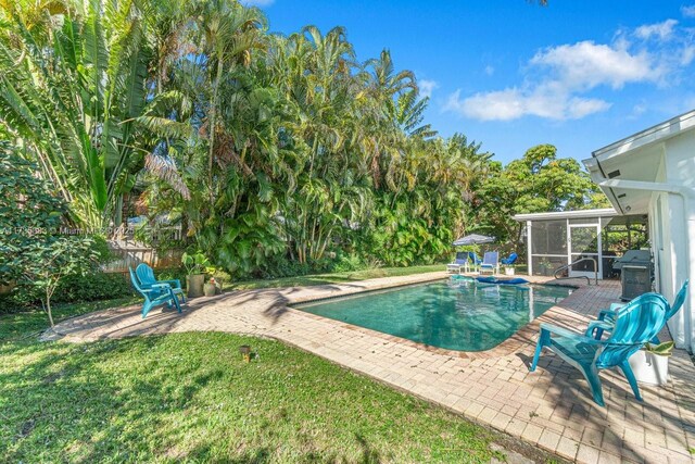 view of swimming pool featuring a patio and grilling area