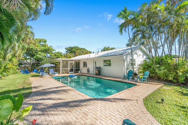 view of pool with a patio, a yard, and grilling area