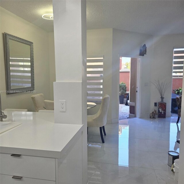 kitchen featuring stainless steel appliances, white cabinetry, and a textured ceiling