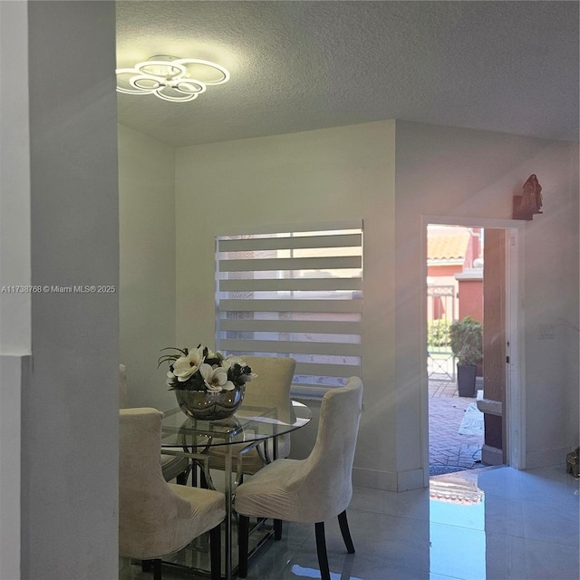 tiled dining room with a textured ceiling