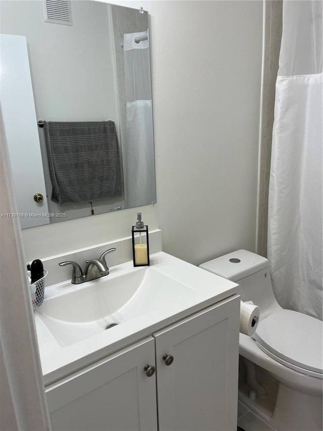 bathroom featuring vanity, curtained shower, and toilet