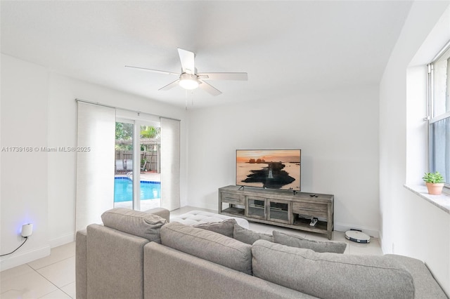 living room with light tile patterned floors, baseboards, and ceiling fan