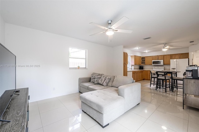 living room featuring visible vents, ceiling fan, and light tile patterned floors