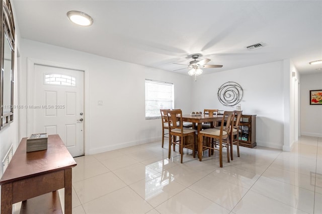 dining space with light tile patterned floors, baseboards, a ceiling fan, and visible vents