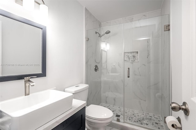 bathroom with toilet, vanity, and a marble finish shower