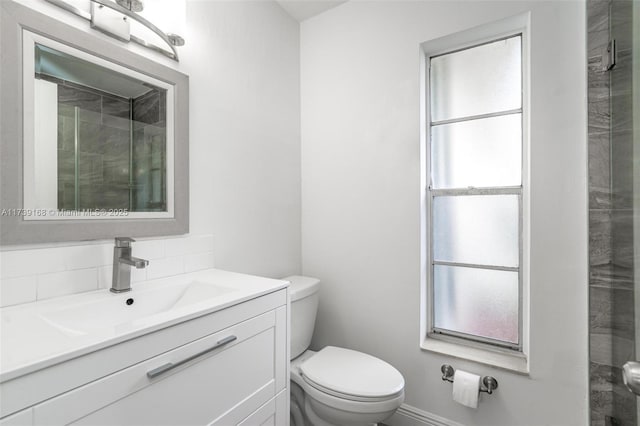 bathroom with tasteful backsplash, vanity, and toilet