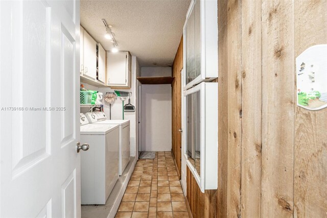 clothes washing area with rail lighting, cabinets, light tile patterned floors, washing machine and clothes dryer, and a textured ceiling