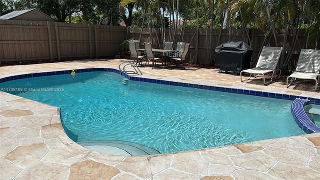 view of swimming pool with a patio area, fence, a fenced in pool, and area for grilling