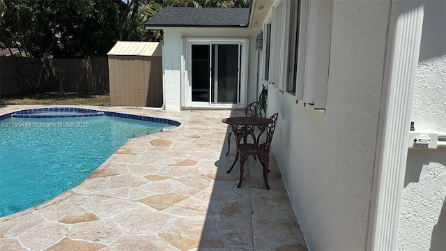 view of pool with a patio area, a fenced in pool, and fence