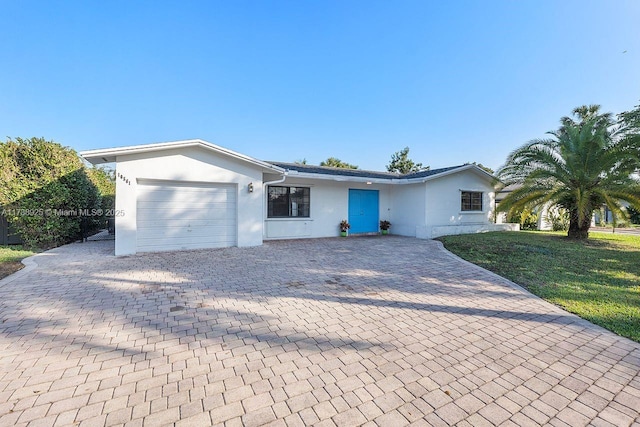 single story home featuring a garage and a front yard