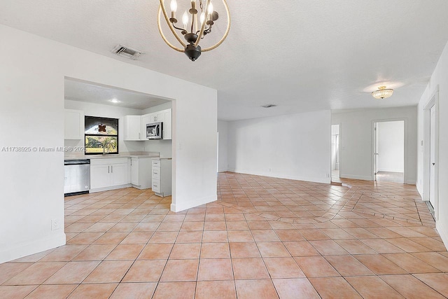 unfurnished living room featuring light tile patterned floors, a textured ceiling, and a chandelier