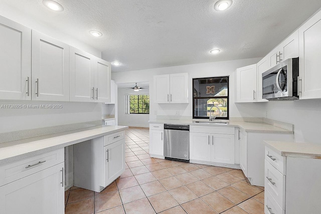 kitchen with appliances with stainless steel finishes, sink, and white cabinets