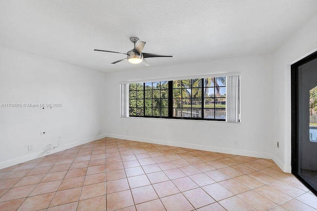 spare room with ceiling fan, light tile patterned floors, plenty of natural light, and a textured ceiling