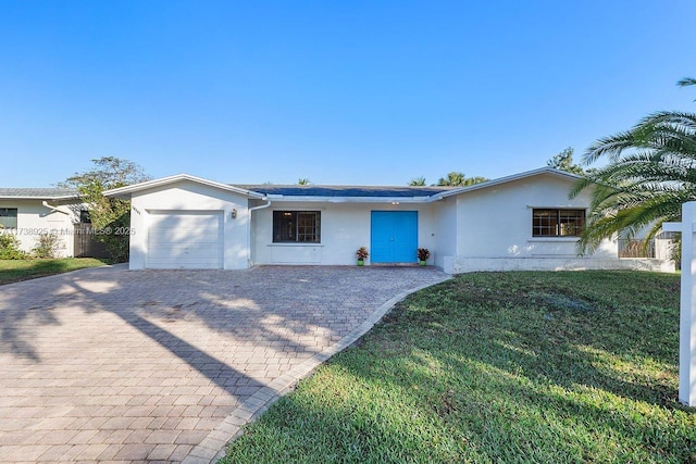 ranch-style house featuring a garage and a front lawn