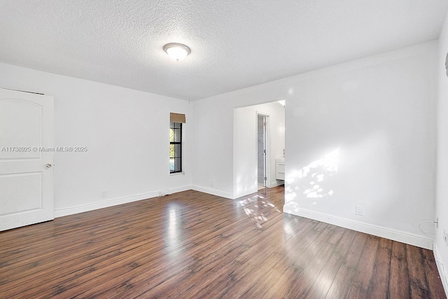 unfurnished room with dark hardwood / wood-style flooring and a textured ceiling