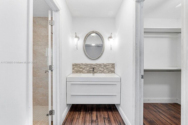 bathroom with tasteful backsplash, vanity, and hardwood / wood-style floors