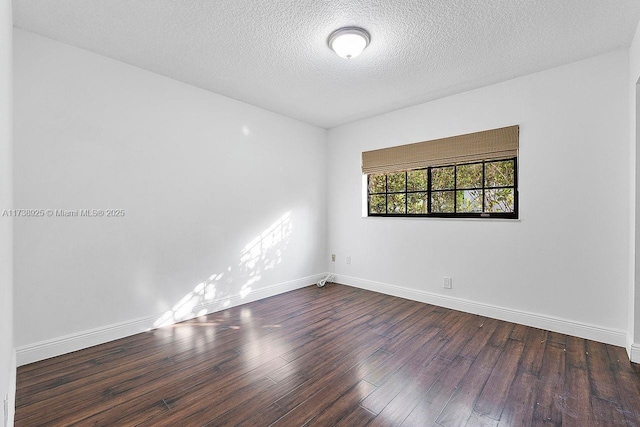 unfurnished room with a textured ceiling and dark hardwood / wood-style flooring