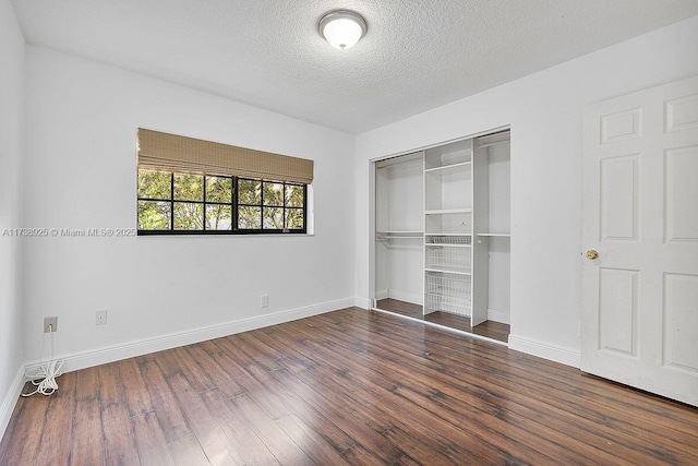 unfurnished bedroom featuring dark wood-type flooring, a closet, and a textured ceiling