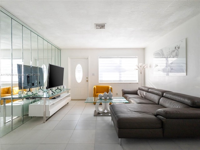 tiled living room featuring a textured ceiling