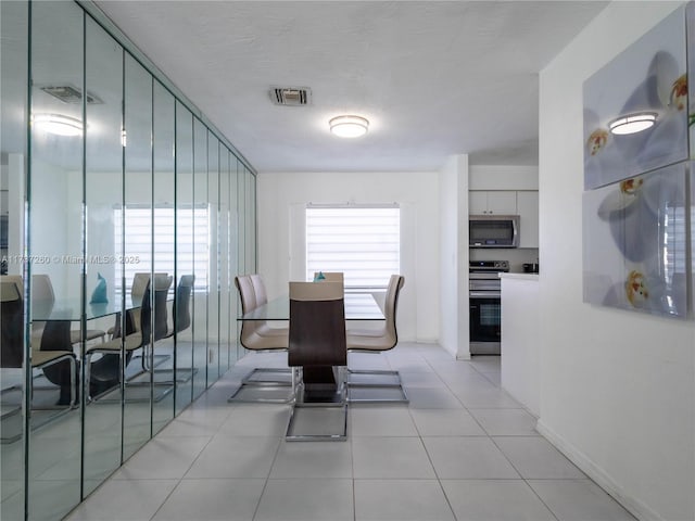 tiled dining area featuring a textured ceiling