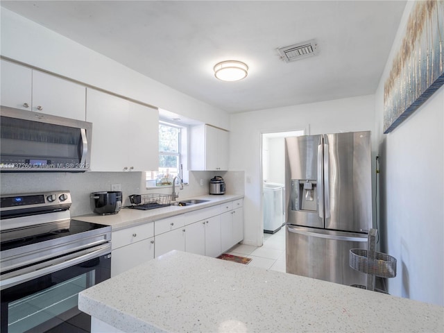 kitchen with tasteful backsplash, stainless steel appliances, sink, and white cabinets