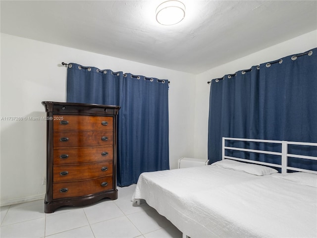 bedroom featuring vaulted ceiling and light tile patterned flooring