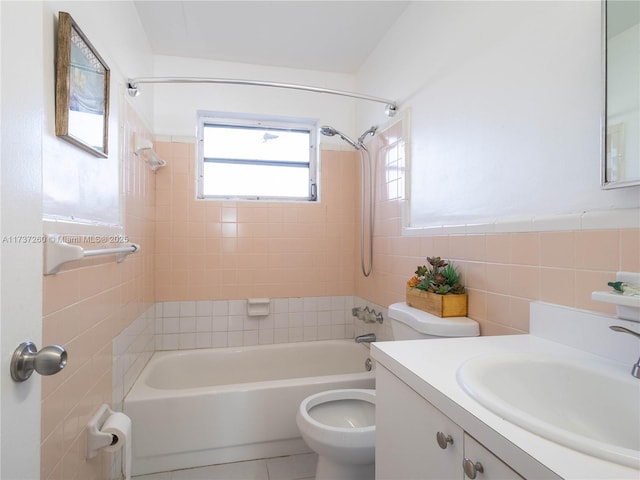 full bathroom with toilet, tile walls, vanity, tiled shower / bath combo, and tile patterned flooring