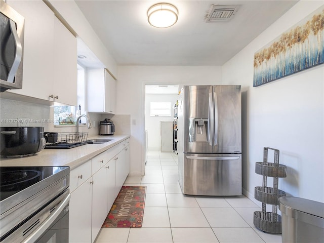 kitchen featuring white cabinetry, stainless steel appliances, sink, and plenty of natural light