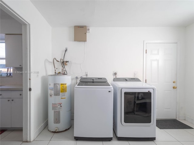 clothes washing area with light tile patterned floors, washing machine and dryer, and water heater