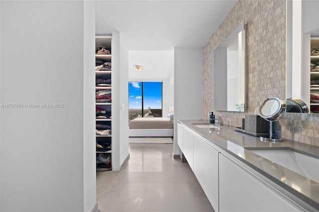 bathroom featuring tile patterned floors, vanity, and decorative backsplash