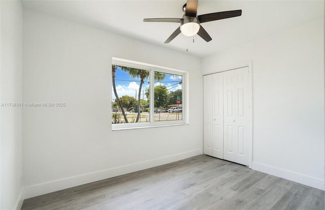 unfurnished bedroom with ceiling fan, light hardwood / wood-style floors, and a closet