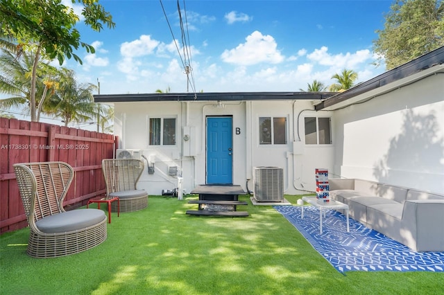 back of house with central AC and a lawn