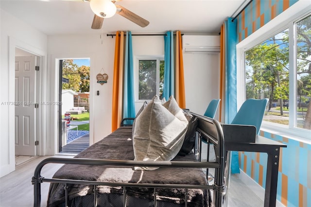 bedroom featuring access to outside, a wall unit AC, and light hardwood / wood-style flooring