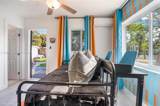 interior space featuring ceiling fan, a wall mounted AC, and hardwood / wood-style floors