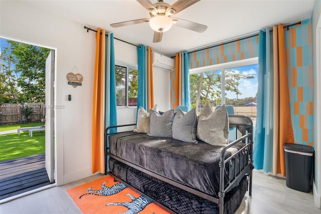 bedroom featuring ceiling fan, multiple windows, access to exterior, and a wall unit AC