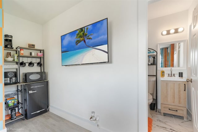 interior space with a sink, baseboards, and marble finish floor