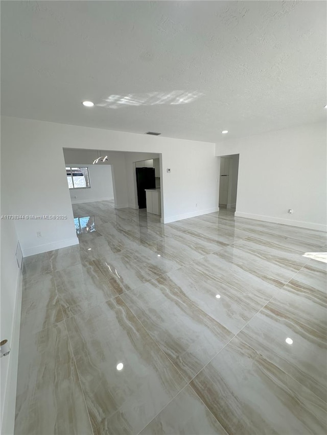 unfurnished room featuring a textured ceiling