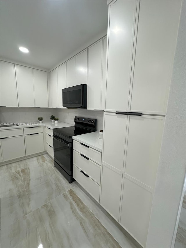 kitchen featuring black / electric stove, white cabinetry, and tasteful backsplash