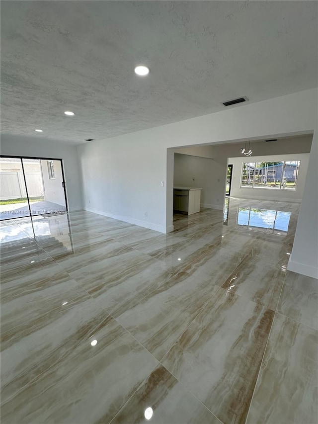 unfurnished living room with a healthy amount of sunlight and a textured ceiling