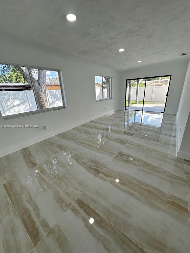 unfurnished room with a textured ceiling