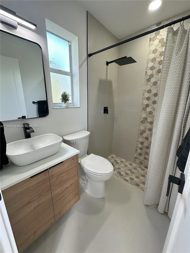 bathroom featuring vanity, curtained shower, and toilet