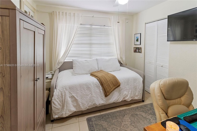 bedroom with a closet, ceiling fan, and light tile patterned flooring