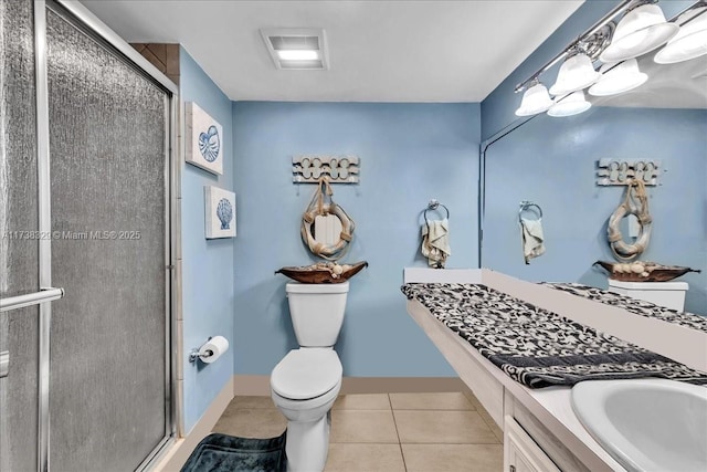 bathroom featuring vanity, a shower with door, tile patterned floors, and toilet