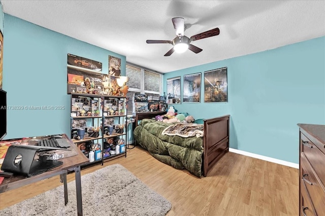 bedroom featuring ceiling fan, a textured ceiling, and light wood-type flooring