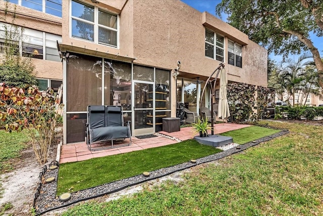 rear view of house with a patio area and a lawn